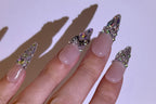 Hand with decorative nail art on a plain background