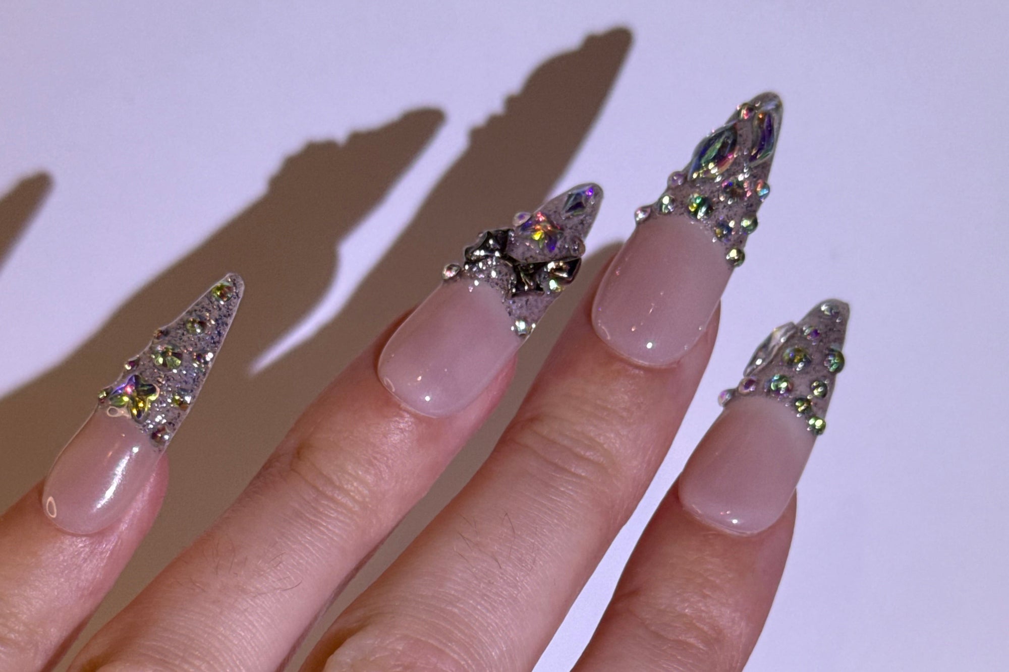 Hand with decorative nail art on a plain background